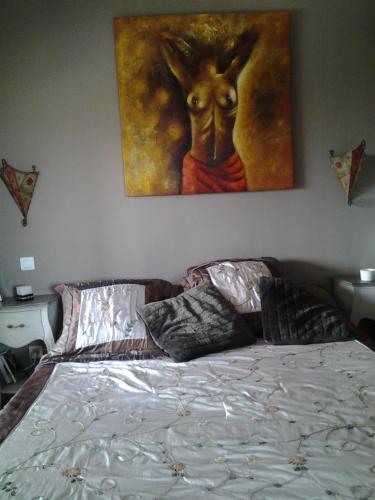 a bedroom with a bed with a painting on the wall at Villa de charme avec piscine in Ghisonaccia