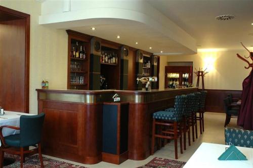 a bar with chairs and a counter in a room at Hotel Villa in Prague