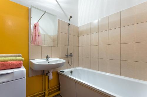 ein Badezimmer mit einem Waschbecken und einer Badewanne in der Unterkunft Apartment 45 Str. Divizii 108 in Woronesch