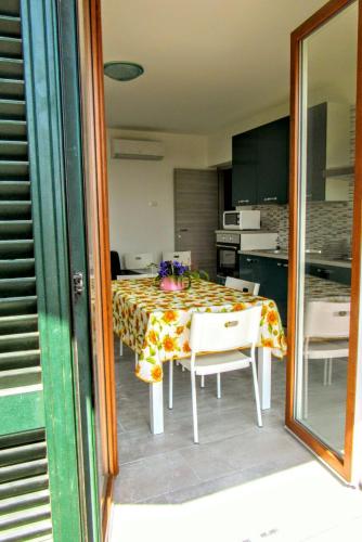a dining room table with chairs and a kitchen at Residenza Christian in Gravedona