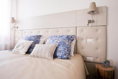 a bedroom with a large bed with blue and white pillows at B&B Al Pozzo di Luce in Venice