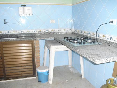 a kitchen with a counter with a stove in it at Casa Temporada em Caraguatatuba in Caraguatatuba