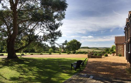 a park with a bench and a tree at Luxury Escape in Hunstanton