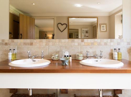 a bathroom with two sinks in front of a mirror at Luxury Escape in Hunstanton