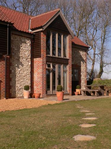 a brick building with potted plants in front of it at Luxury Escape in Hunstanton