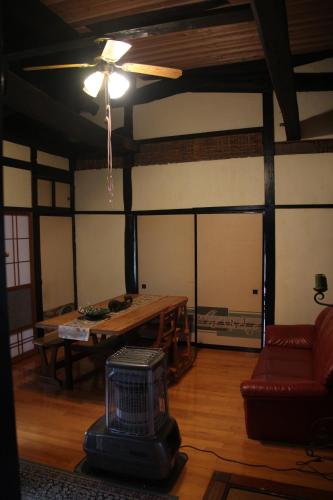 a living room with a table and a ceiling fan at Madarao Farm in Nakano