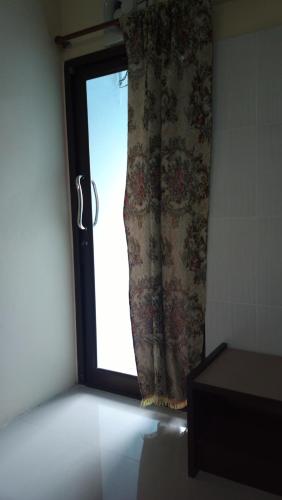 a window with a curtain in a room at Hua Hin Euro City Hotel in Hua Hin