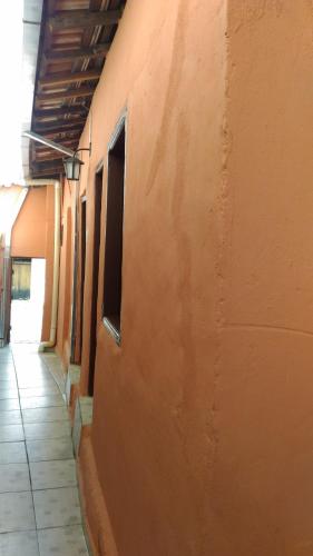 an empty hallway of an orange building with a sidewalk at Suítes São Judas in Pirenópolis