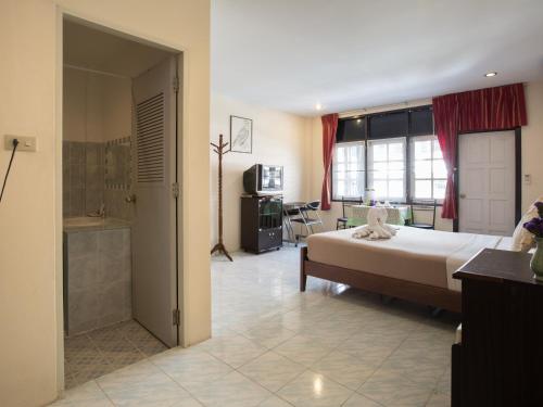 a bedroom with a large bed and a bathroom at Stefan's Guesthouse in Jomtien Beach