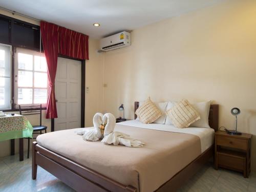 a bedroom with two swans sitting on a bed at Stefan's Guesthouse in Jomtien Beach
