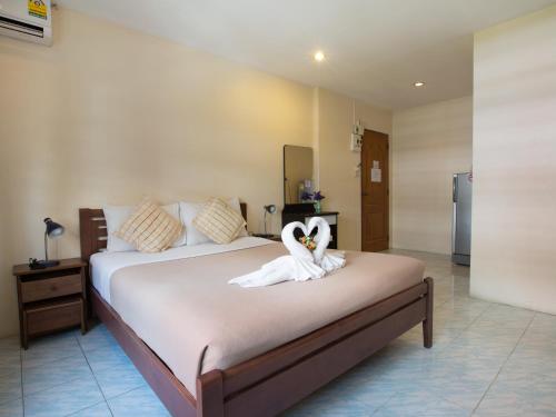 a bedroom with a bed with a swan decoration on it at Stefan's Guesthouse in Jomtien Beach