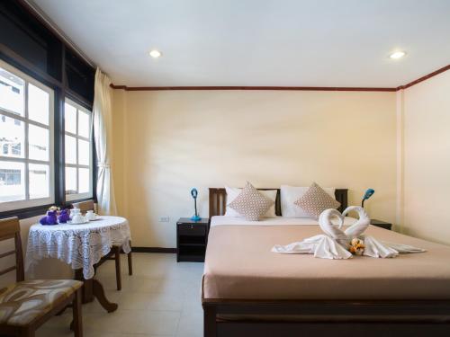 a hotel room with two beds and a table and a table and chairs at Stefan's Guesthouse in Jomtien Beach