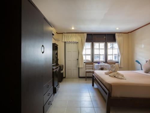a bedroom with two beds and a window and a table at Stefan's Guesthouse in Jomtien Beach