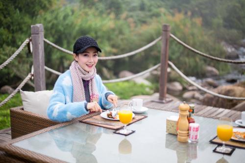 a woman sitting at a table with a plate of food at Namkat Yorla Pa Resort in Ban Kat