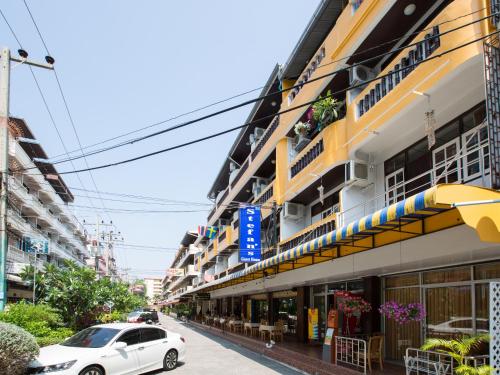 a white car parked in front of a building at Stefan's Guesthouse in Jomtien Beach
