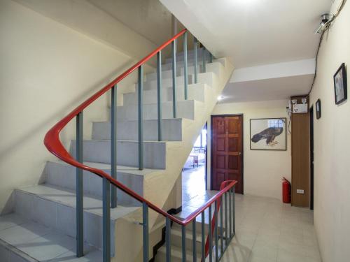 a staircase in a house with a red rail at Stefan's Guesthouse in Jomtien Beach