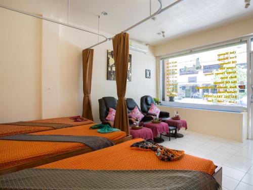 a hotel room with three beds and a window at Stefan's Guesthouse in Jomtien Beach