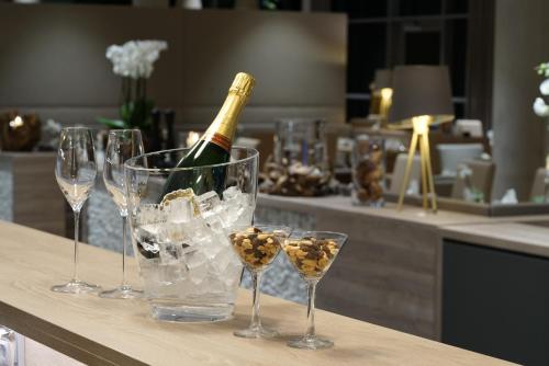 a bottle of champagne and glasses on a counter at WONNEMAR Resort-Hotel in Wismar
