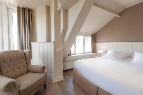 a bedroom with a large bed and a chair at Hotel Heritage in De Haan