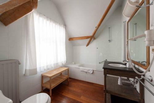 uma casa de banho com um lavatório e uma banheira em Hotel Heritage em De Haan