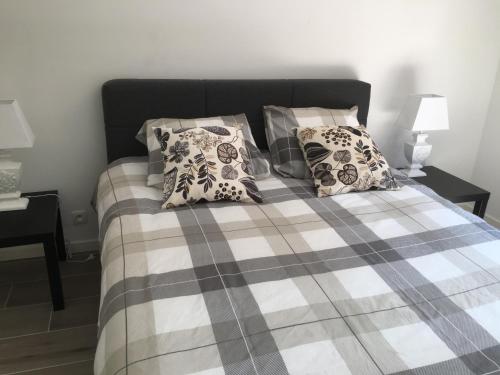 a bedroom with a bed with a plaid blanket and pillows at Apartment Beach in Blankenberge