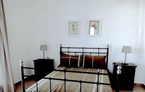 アンティパロス・タウンにあるOrange Apartmentのベッドルーム1室(黒いベッド1台、ナイトスタンド2台付)