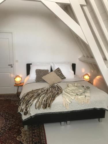 a bedroom with a bed with a blanket and pillows at NR22 Leiden in Leiden