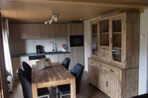 uma cozinha e sala de jantar com uma mesa de madeira e cadeiras em Vakantiehuisje De Haan em De Haan