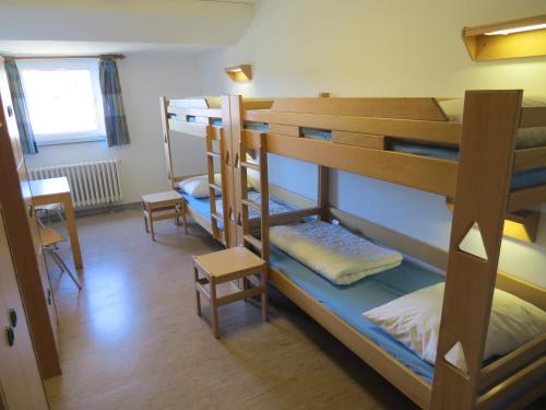 a room with three bunk beds and a table at Jugendherberge List in List