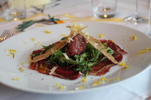 a white plate with a salad on a table at Berggasthof Pension Pfitscher in Unsere Liebe Frau im Walde