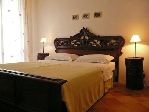 un grande letto in una camera da letto con due lampade di Casa Rondini a Montegabbione