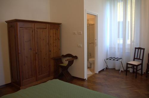 ゴリツィアにあるB&B Ai Confini dell'Imperoのベッドルーム(木製キャビネット、ベッド付)