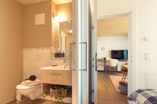 a bathroom with a toilet and a sink at Simply Home Apartments in Ueberackern