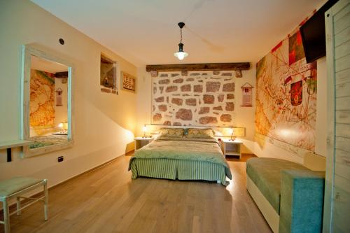 a bedroom with a bed and a stone wall at Medin di Lastua in Petrovac na Moru