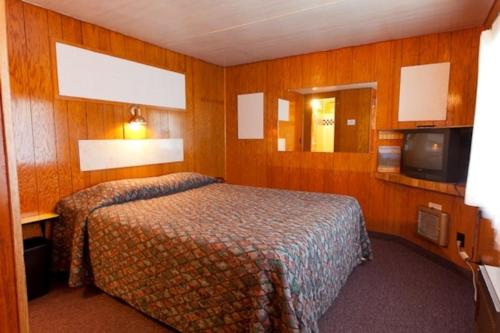 a hotel room with a bed and a tv at Robbins Motel in Bar Harbor