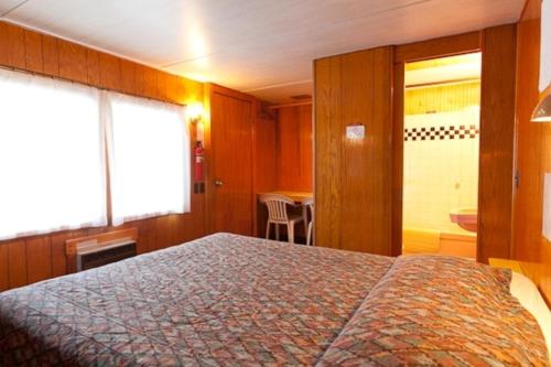 a bedroom with a large bed and a bathroom at Robbins Motel in Bar Harbor