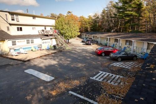 a parking lot with cars parked in front of buildings at Robbins Motel in Bar Harbor
