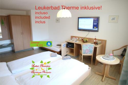 a living room with a bed and a desk at Hotel Paradis-Leukerbad-Therme in Leukerbad