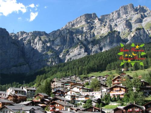 a town in front of a mountain with houses at Hotel Paradis-Leukerbad-Therme in Leukerbad