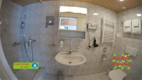 a bathroom with a sink and a mirror at Hotel Paradis-Leukerbad-Therme in Leukerbad