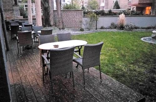 a table and chairs on a patio with a yard at Wasserturm Hotel Mannheim in Mannheim
