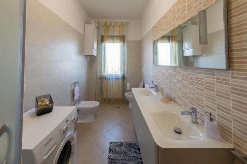 La salle de bains est pourvue d'un lavabo, de toilettes et d'un miroir. dans l'établissement Appartamenti Brufa Civico 13/17, à Brufa
