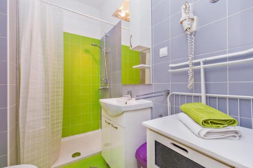 ドゥブロヴニクにあるApartment & Room Joyの- 緑と青のタイル張りのバスルーム(シンク付)