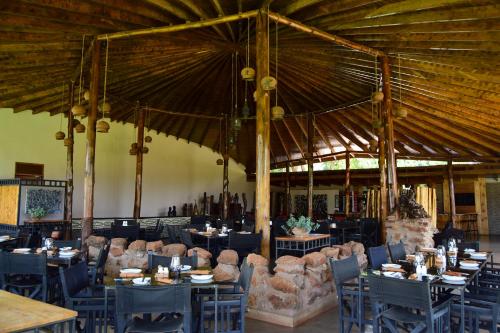 a restaurant with tables and chairs and a large ceiling at Ameg Lodge Kilimanjaro in Moshi