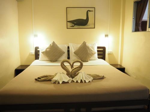 a bed with two heart shaped towels on it at Stefan's Guesthouse in Jomtien Beach