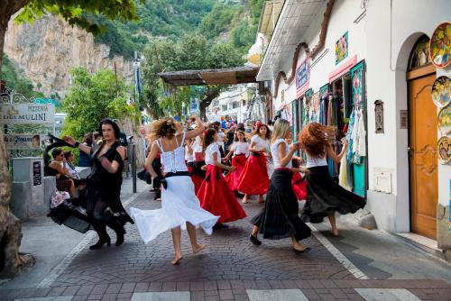 a group of young women dancing on a city street at Villa Miriam in Gragnano