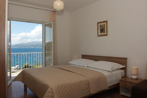 1 dormitorio con cama y vistas al océano en Apartment Marina en Postira