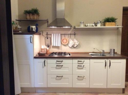 a kitchen with white cabinets and a stove top oven at B&B Del Corso in Mazara del Vallo