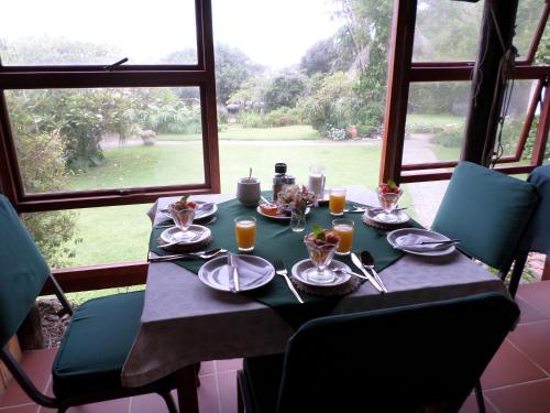 een tafel met borden eten voor een raam bij Geckos B&B and Self-catering in Coffee Bay