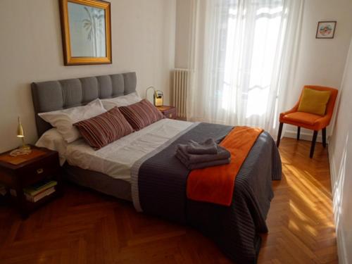 ein Schlafzimmer mit einem großen Bett und einem Stuhl in der Unterkunft Charmant appartement au centre de Nice in Nizza